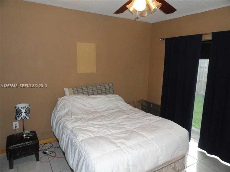 15636 Southwest 35th Terrace Miami, FL 33185 - Photo 8 of 18 a large bed sitting in a bedroom next to a lamp and a chandelier