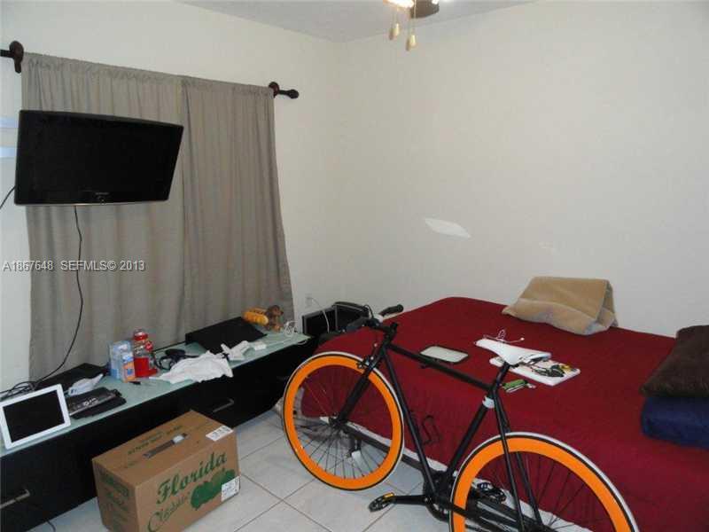 15636 Southwest 35th Terrace Miami, FL 33185 - Photo 10 of 18 a bedroom with a bed and a flat screen tv