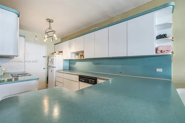 a kitchen with stainless steel appliances granite countertop a refrigerator a stove and a sink