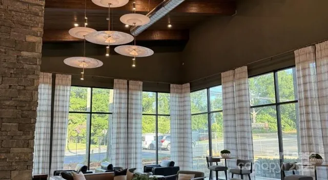 a view of a dining room with furniture large windows and wooden floor