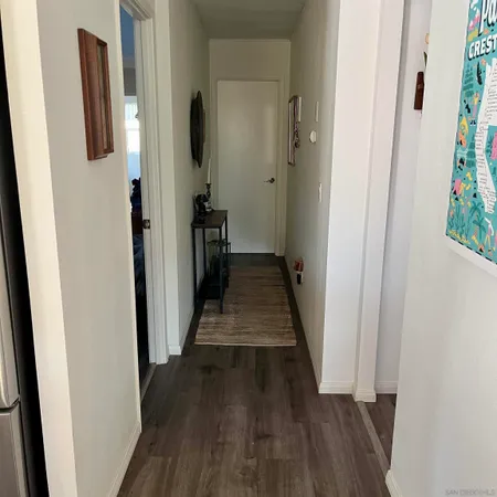 a view of a hallway with wooden floor and stairs