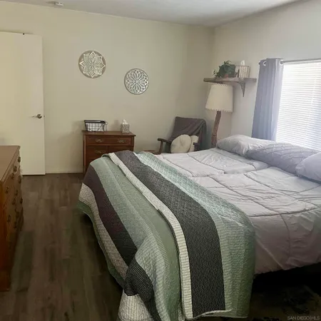 a bedroom with a bed and a lamp on dresser