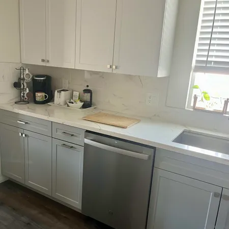 a kitchen with a sink cabinets and a window