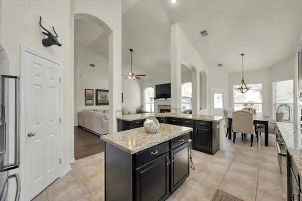 an open kitchen with granite countertop kitchen island white cabinets and stainless steel appliances