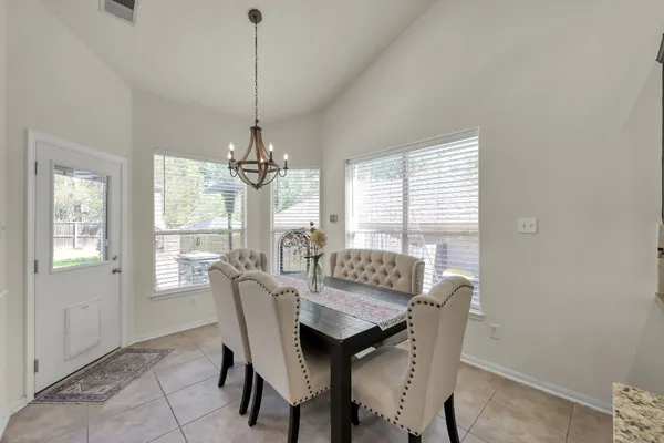 a dining room with furniture a chandelier and window