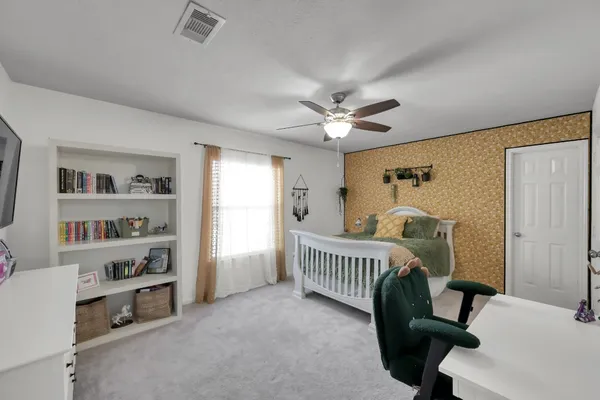 a bedroom with a bed a chandelier and a flat screen tv