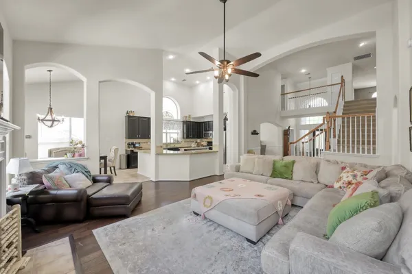 a living room with furniture kitchen view and a chandelier