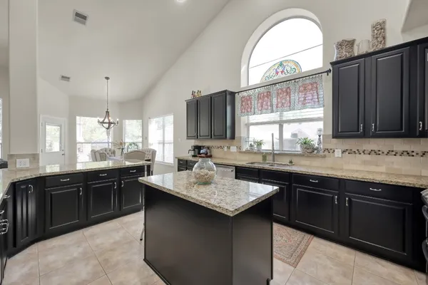a kitchen with granite countertop a sink stove and cabinets