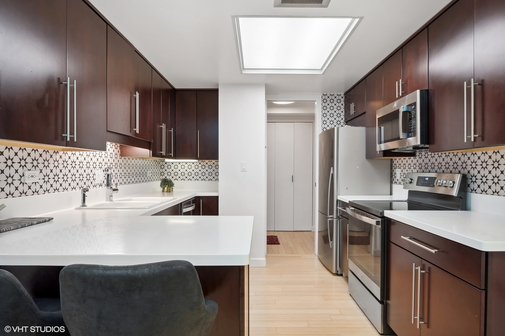 40 East Delaware Place, Unit 1003 Chicago, IL 60611 - Photo 9 of 22 a kitchen with stainless steel appliances a sink stove and refrigerator