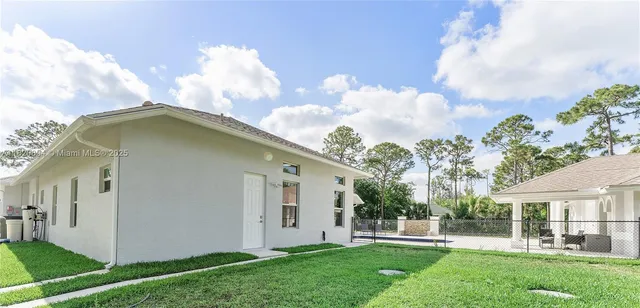 a view of a house with swimming pool and sitting area