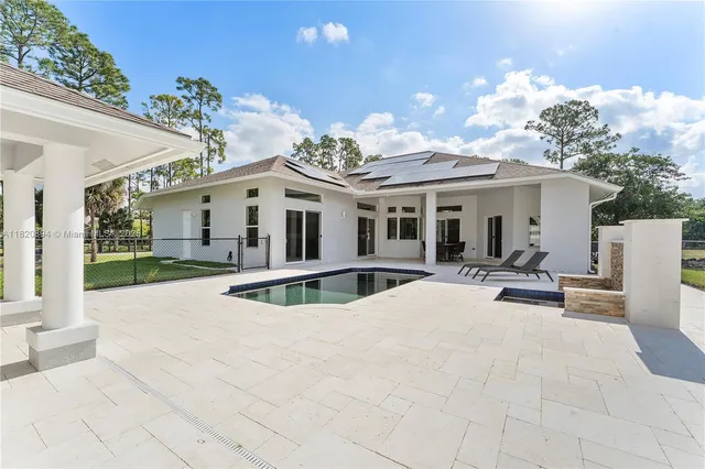a view of a hallway with wooden floor and a living room