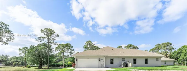 a view of a house with backyard and tree