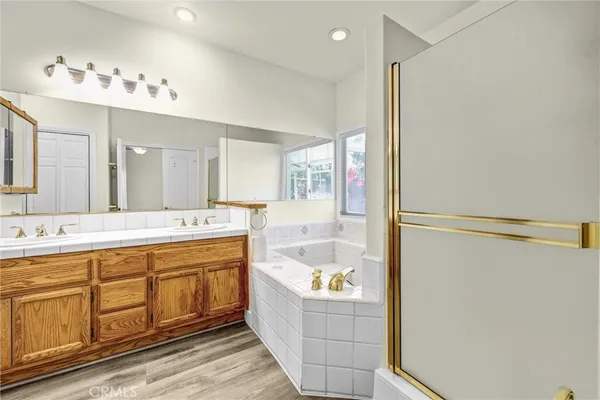 a bathroom with a tub sink and mirror