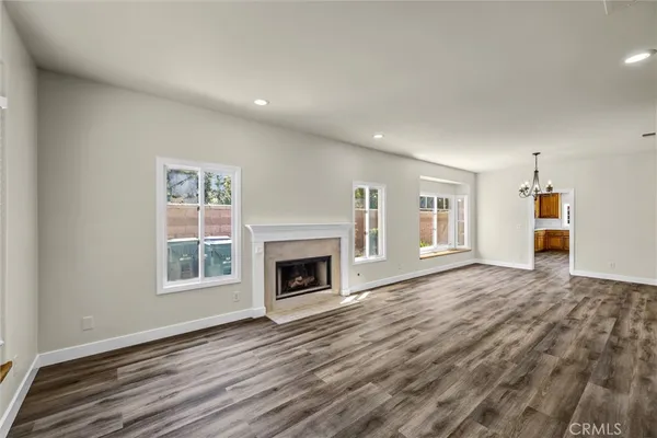 a view of empty room with wooden floor and fireplace