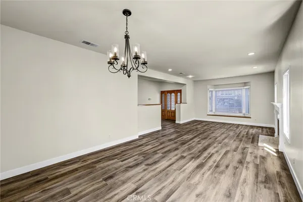 a view of empty room with wooden floor and window