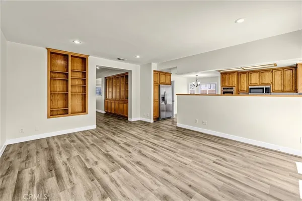 a view of empty room with wooden floor and window