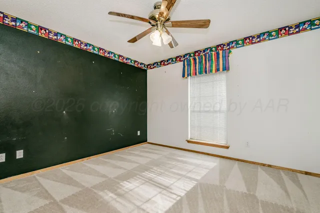 a view of a livingroom with a chandelier fan and wooden floor