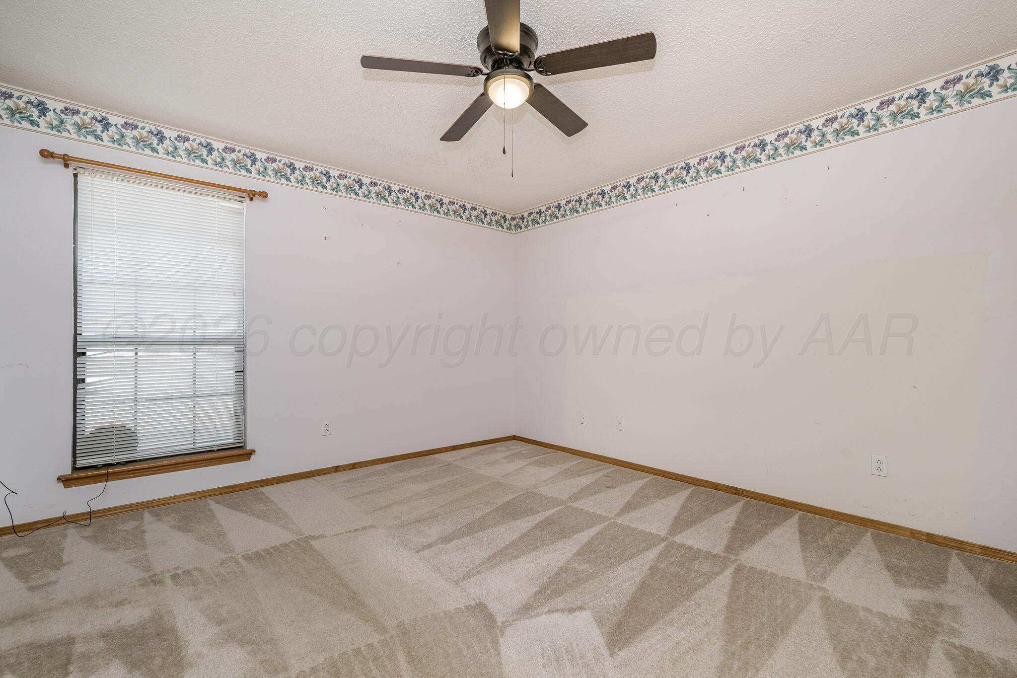 2904 Laguna Drive Amarillo, TX 79110 - Photo 12 of 17 an empty room with windows and fan