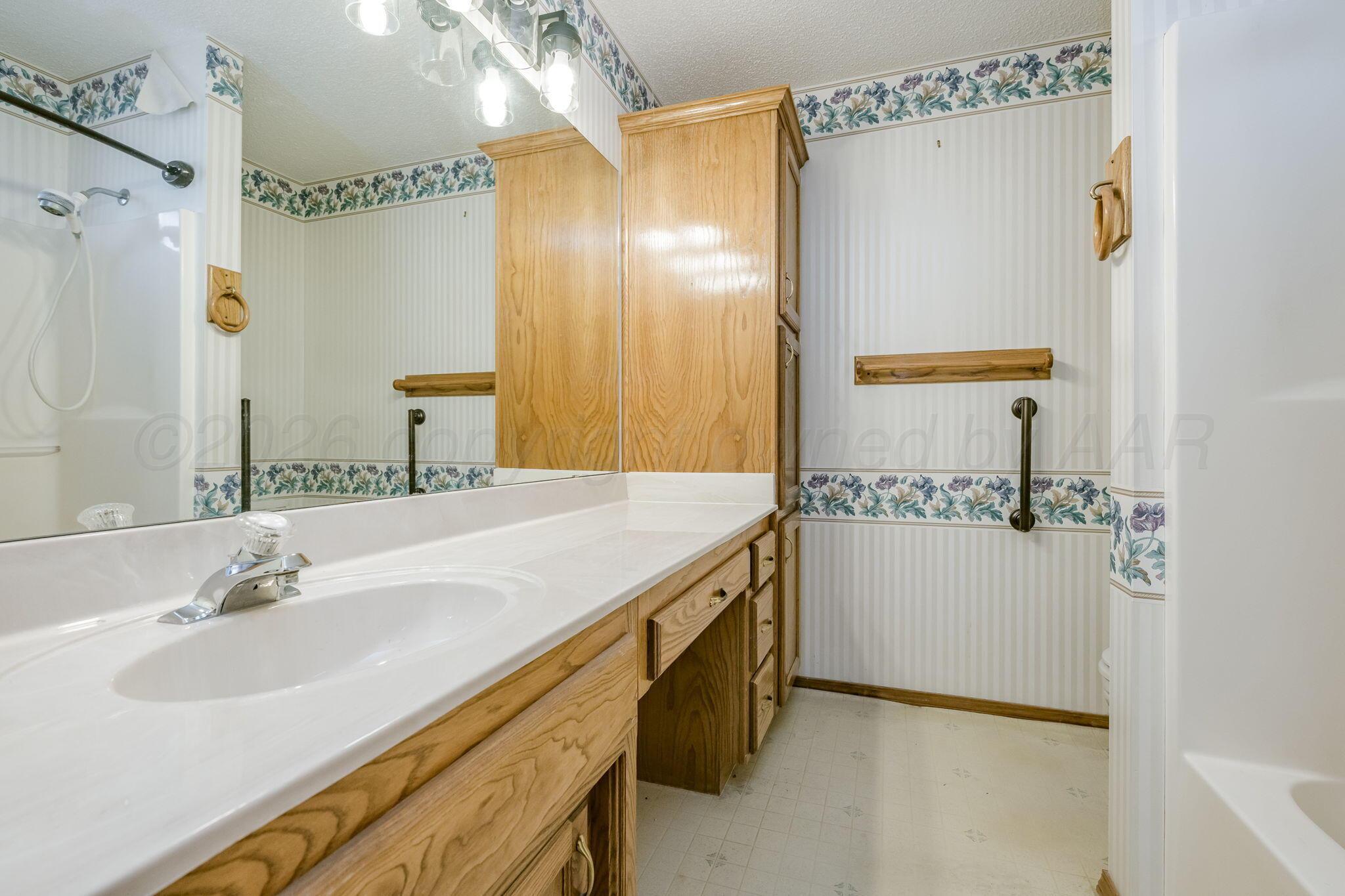 2904 Laguna Drive Amarillo, TX 79110 - Photo 14 of 17 a bathroom with a sink and a mirror