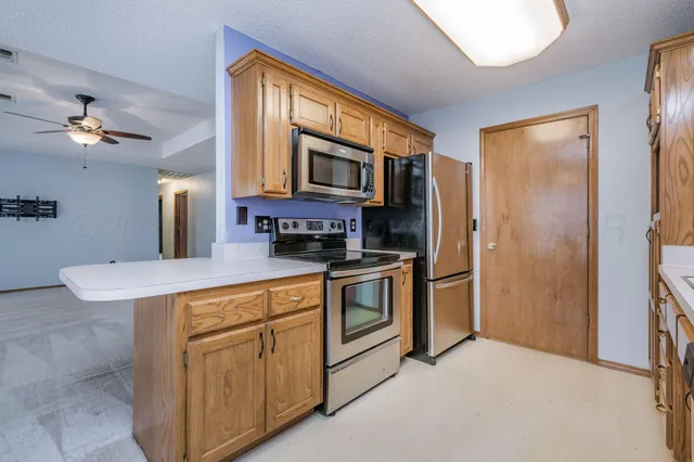 a kitchen with stainless steel appliances granite countertop a refrigerator a stove a sink dishwasher and a microwave oven