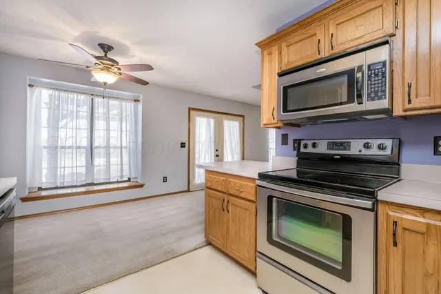 a kitchen with stainless steel appliances granite countertop a stove microwave and cabinets