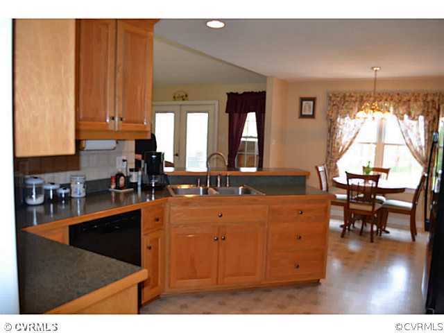 1541 Johns Road Carson, VA 23830 - Photo 8 of 24 a kitchen with stainless steel appliances granite countertop a refrigerator a sink dishwasher a dining table and chairs with wooden floor