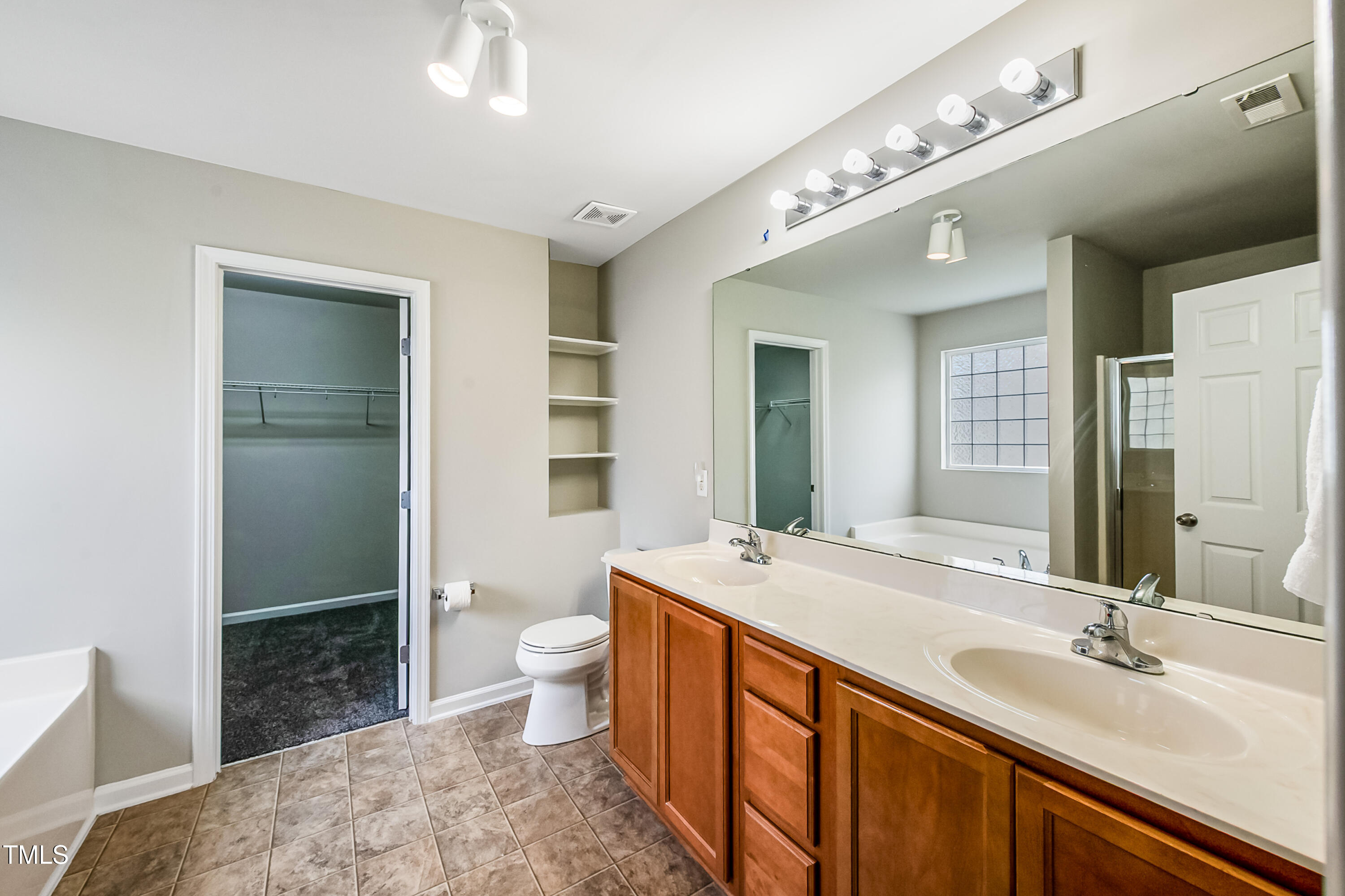 1116 Crendall Way Wake Forest, NC 27587 - Photo 21 of 33 a spacious bathroom with a sink a toilet a mirror and shower