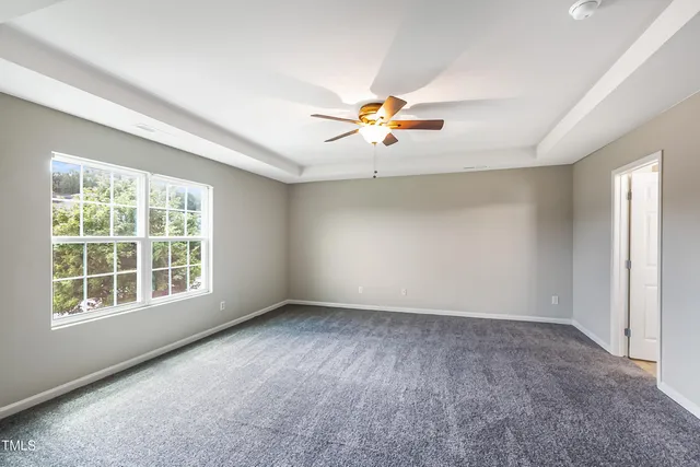 an empty room with a window and a ceiling fan