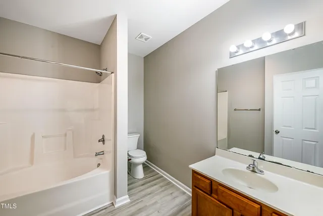 a bathroom with a tub a sink and a large mirror