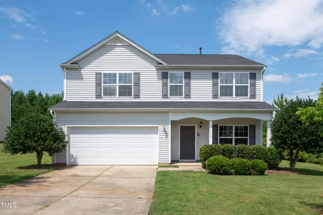 a front view of a house with a garden and plants