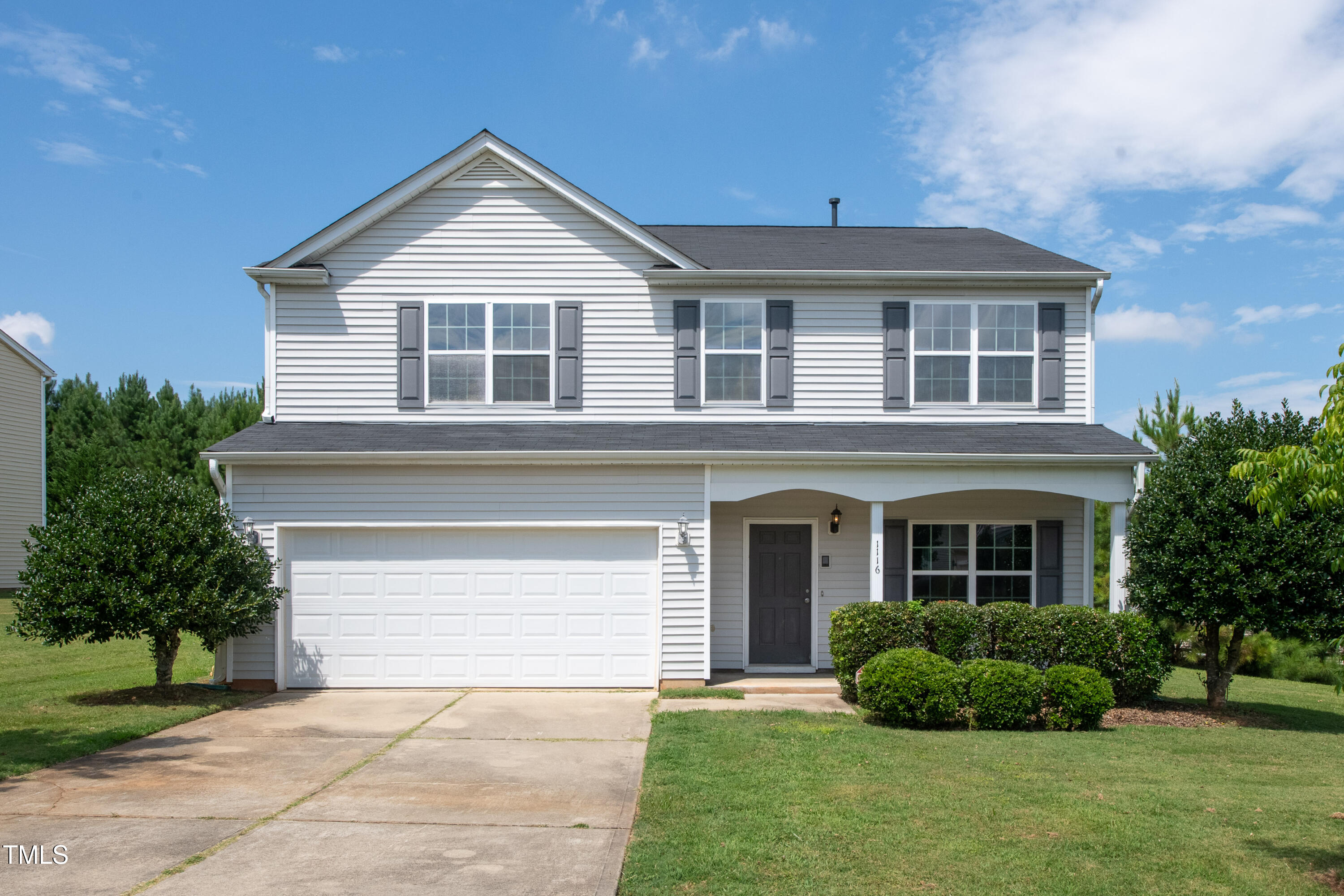 1116 Crendall Way Wake Forest, NC 27587 - Photo 3 of 33 a front view of a house with a garden and plants