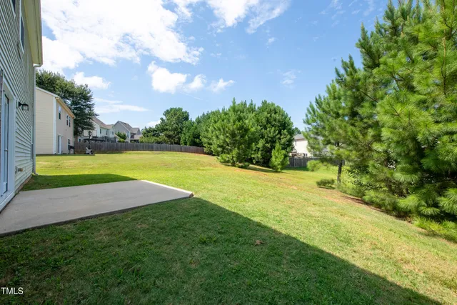 a view of a big yard with swimming pool and green space