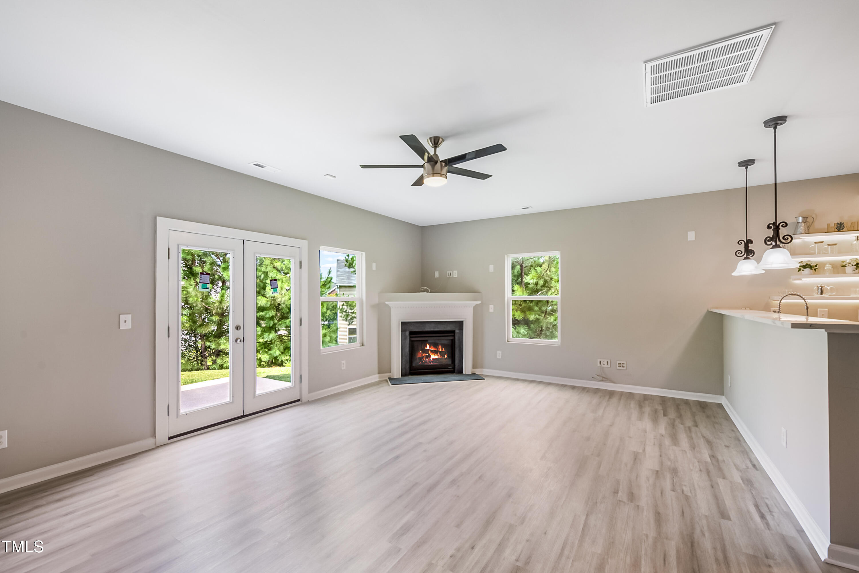1116 Crendall Way Wake Forest, NC 27587 - Photo 9 of 33 an empty room with windows fireplace and wooden floor