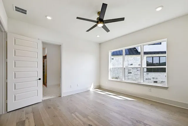 a view of a big room with wooden floor and windows