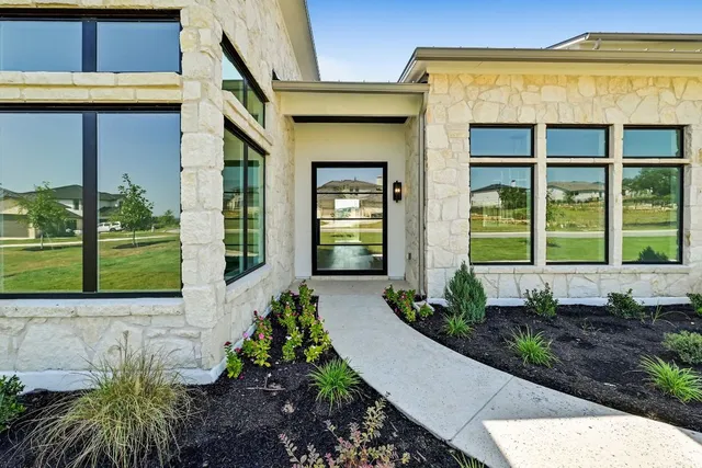 a front view of a house with a yard outdoor seating and mountain view