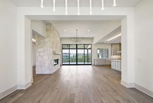 wooden floor fireplace and windows in an empty room