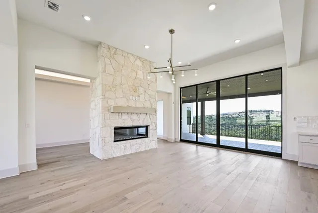 a view of an empty room with a fireplace and a large window