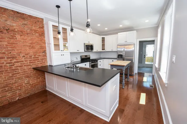 a kitchen with stainless steel appliances granite countertop a sink stove and wooden floor