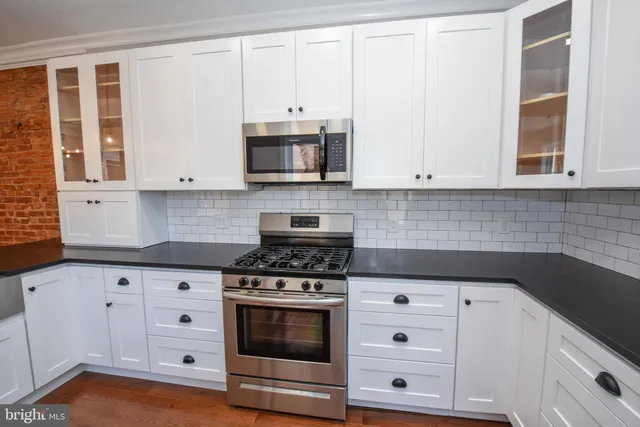 a kitchen with white cabinets and appliances