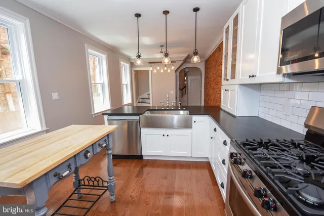 a kitchen with a stove and a wooden floor