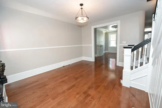 a view of a room with wooden floor and white walls
