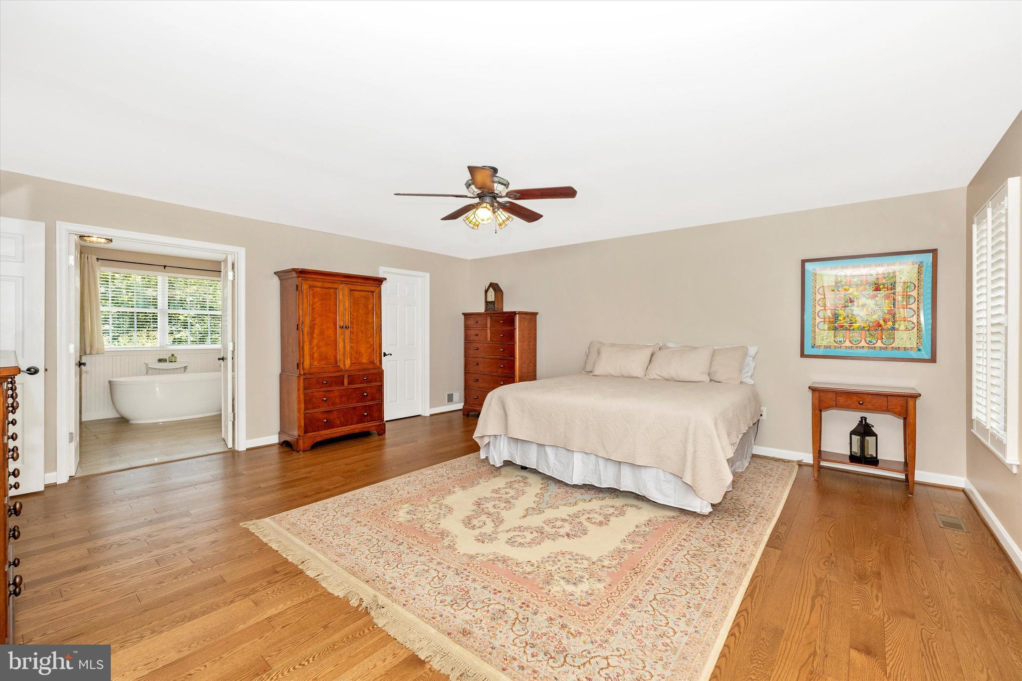 6341 Claridge Drive North Frederick, MD 21701 - Photo 19 of 54 a spacious bedroom with a large bed and a chandelier
