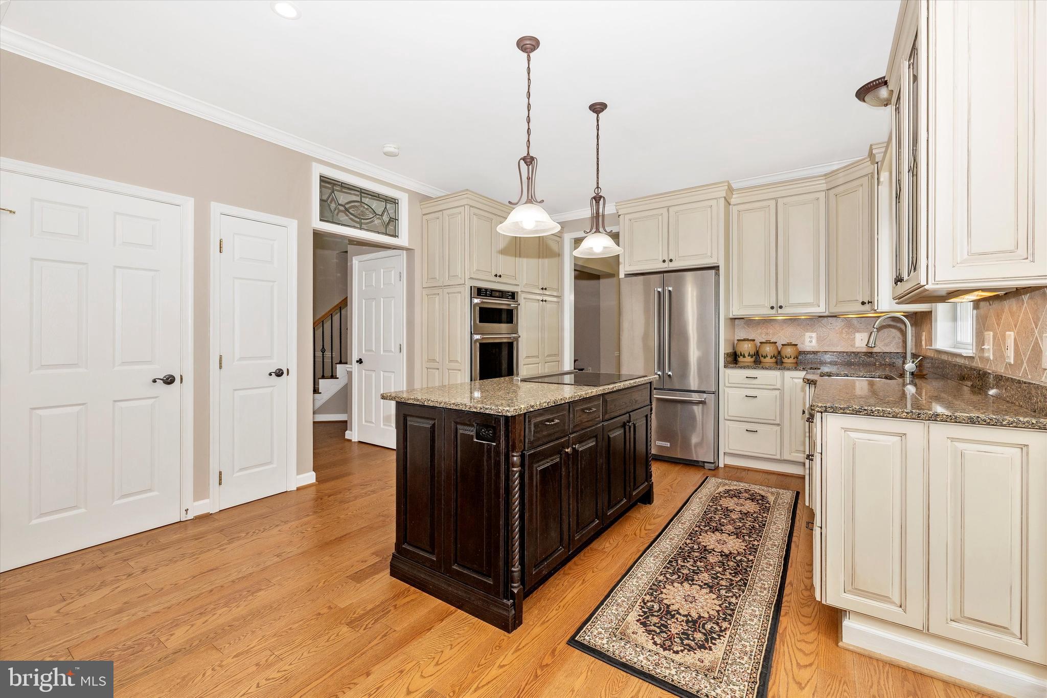 6341 Claridge Drive North Frederick, MD 21701 - Photo 9 of 54 a kitchen with stainless steel appliances granite countertop a stove a sink dishwasher a refrigerator and white cabinets with wooden floor