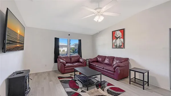 a living room with furniture a flat screen tv and a window