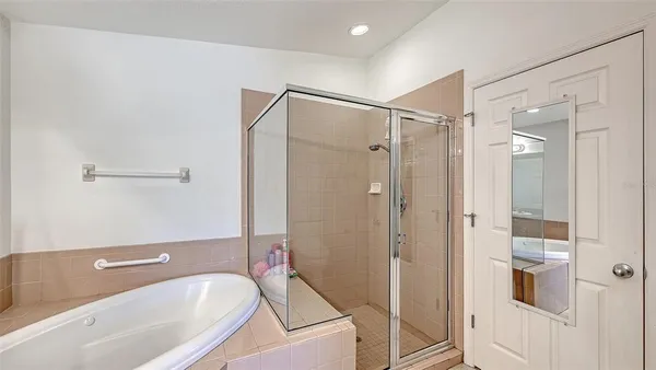 a bathroom with a tub shower vanity and a sink