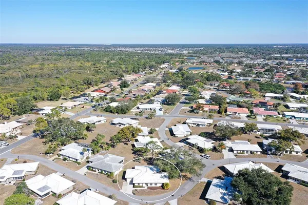 an aerial view of a city with lots of residential buildings and ocean view in back