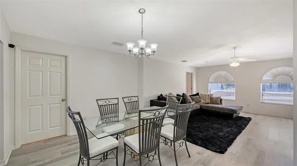 a living room with furniture a chandelier and a mirror