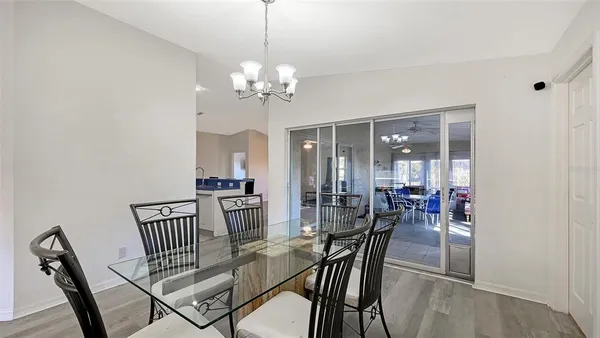 a view of a dining room and livingroom with furniture wooden floor a chandelier