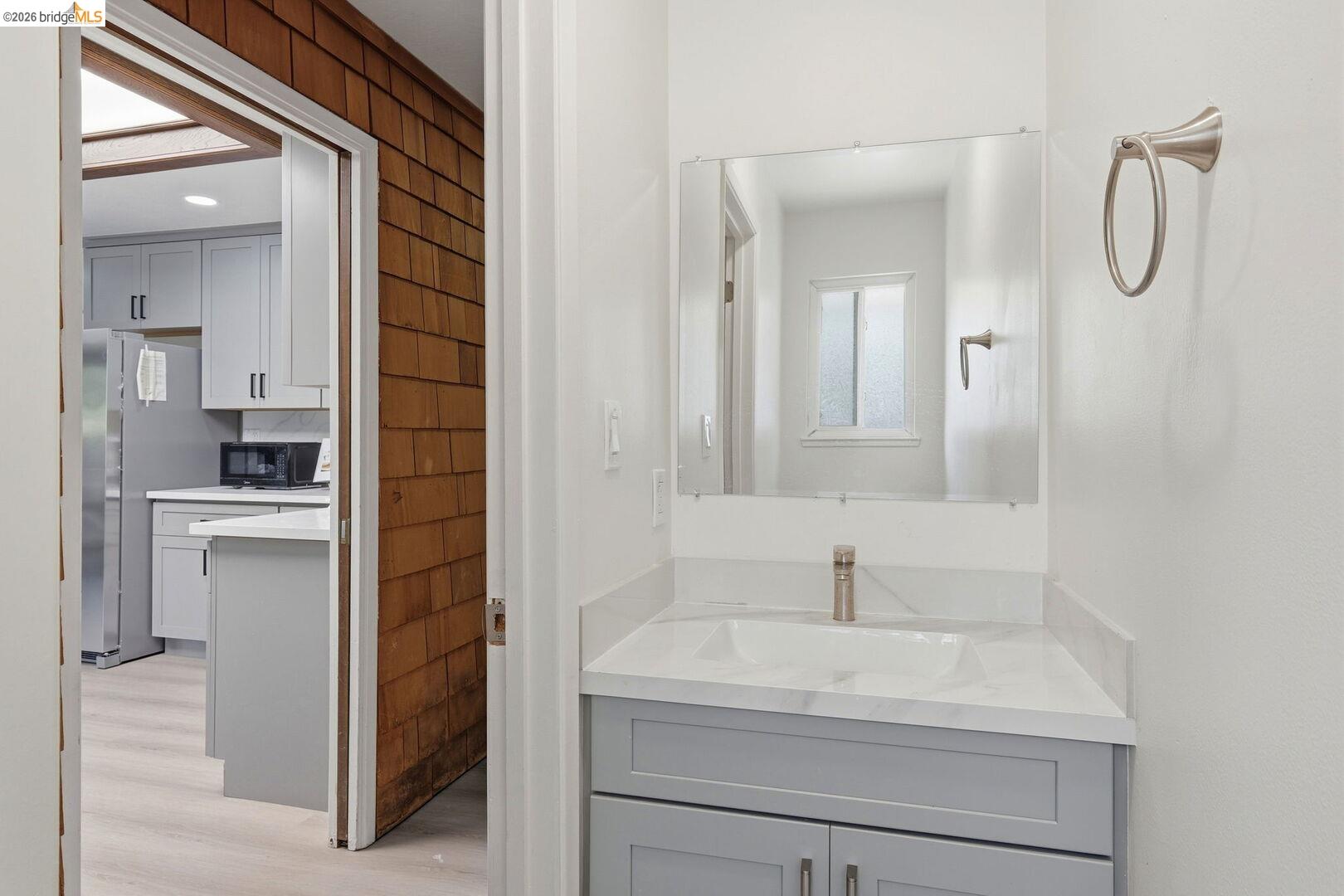 1590 Sunset Road Brentwood, CA 94513 - Photo 27 of 45 Half bathroom vanity with a rectangular undermount sink, a sleek single-handle faucet, and a large wall-mounted mirror