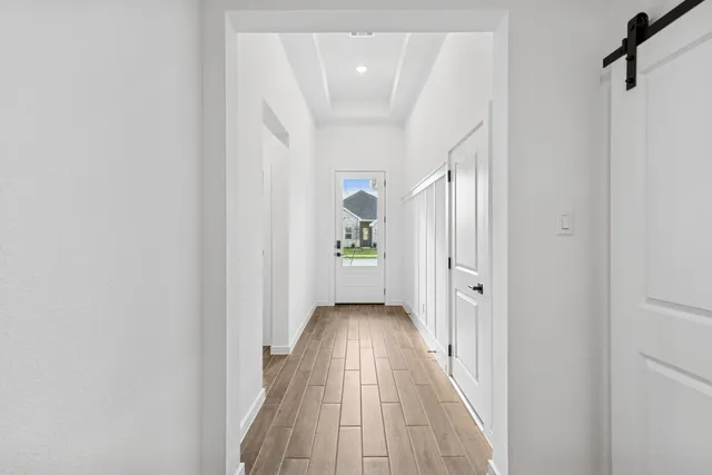 a view of a hallway with wooden floor and staircase